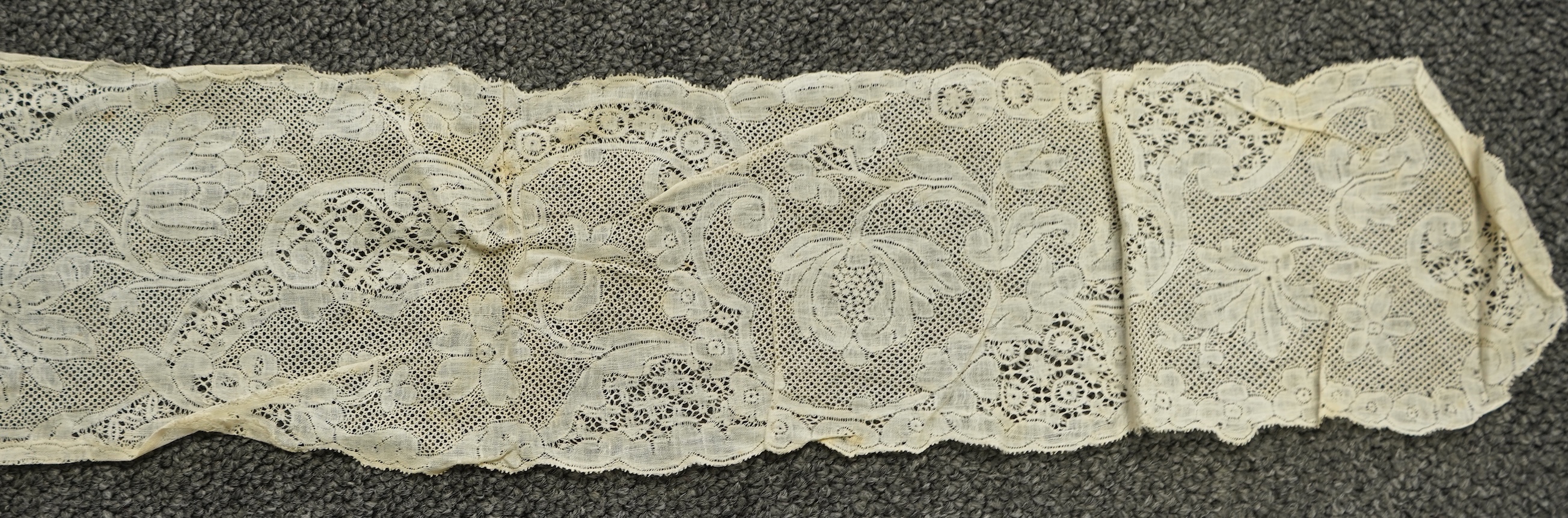 A collection of 18th century needle and bobbin lace. Including an 18th century wide pair of joined Valenciennes lace lappets, a similar 18th century cap back, an ornately worked Point de Alencon cap crown and another sim